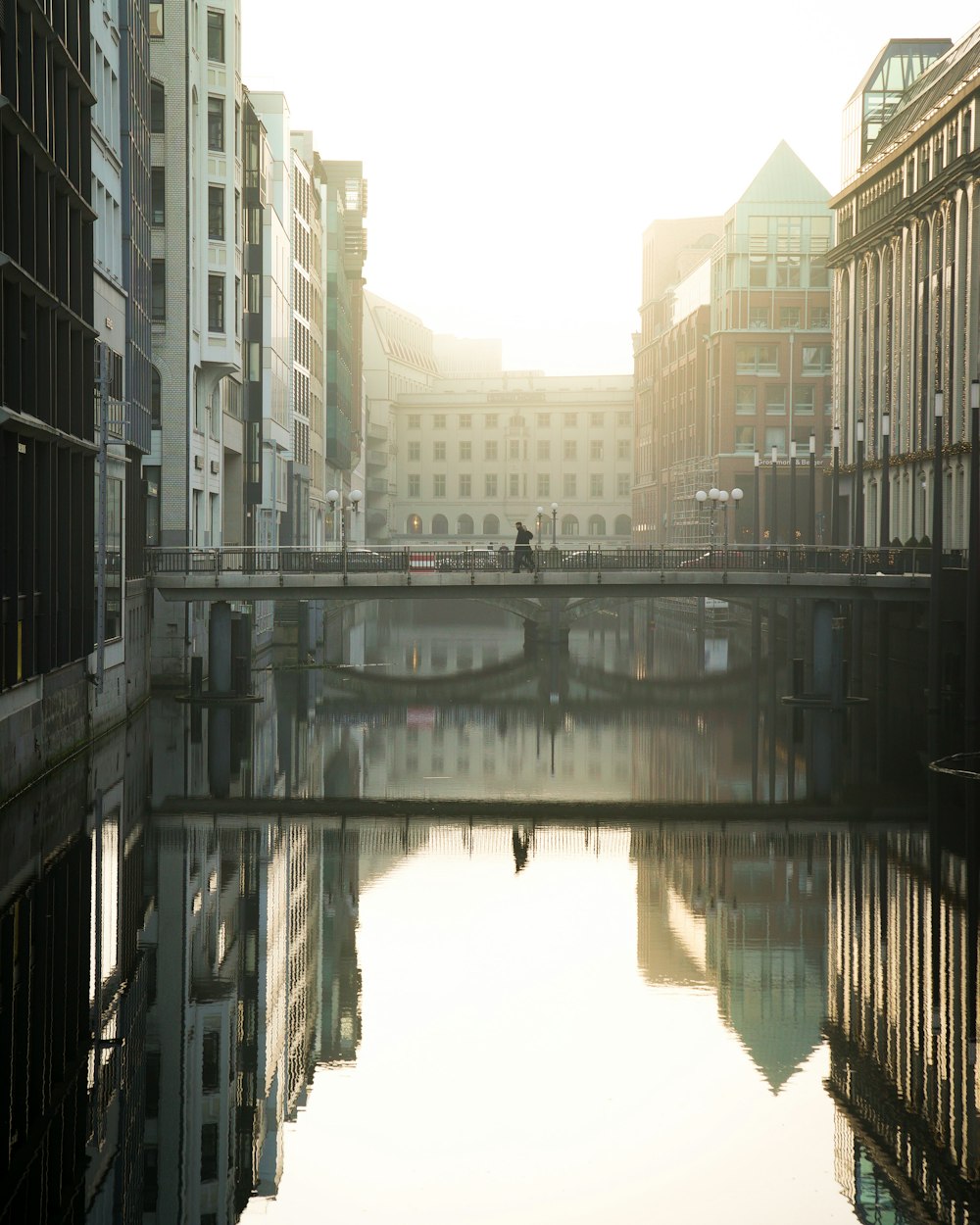 bridge over river between high rise buildings