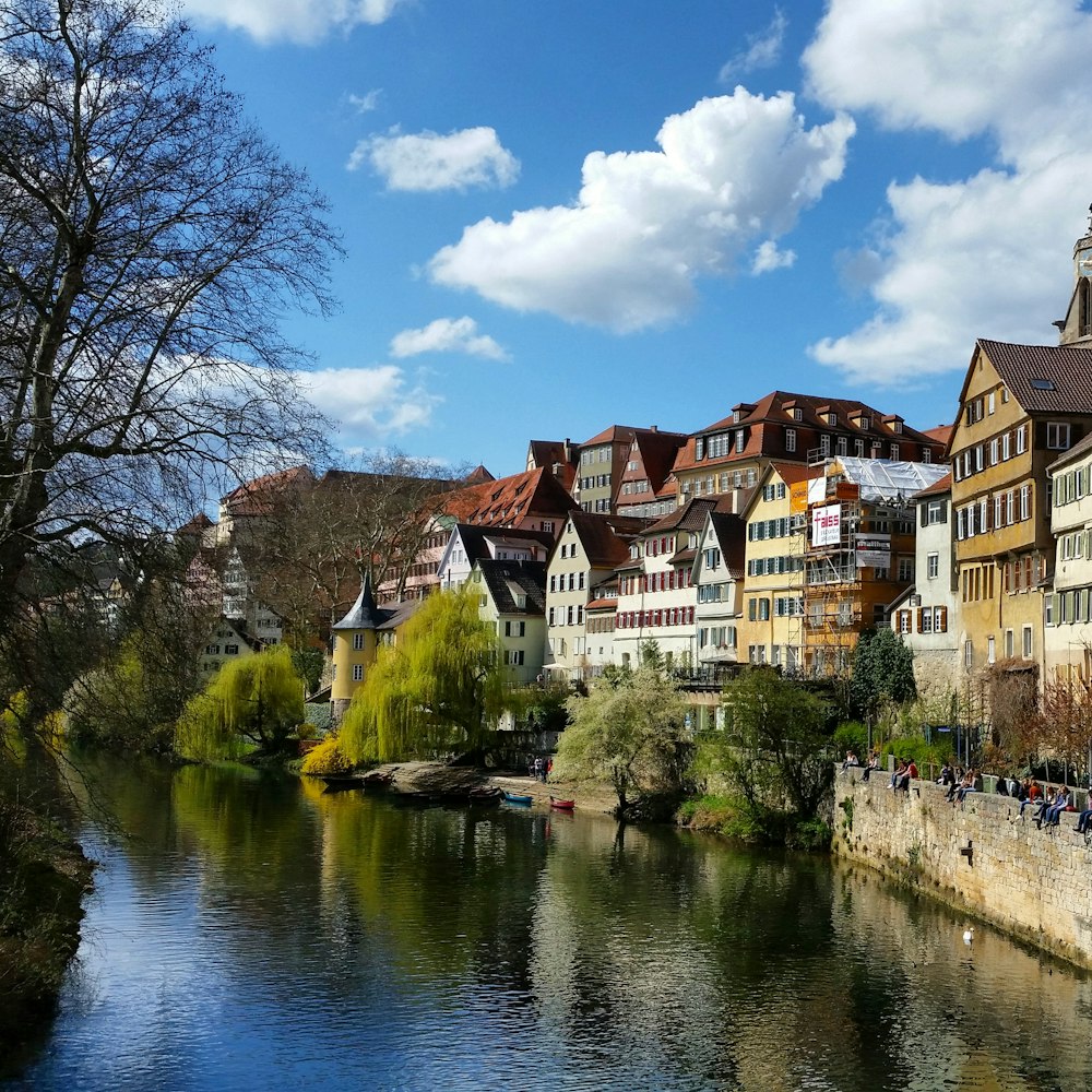 brown and white concrete building beside river under blue sky during daytime