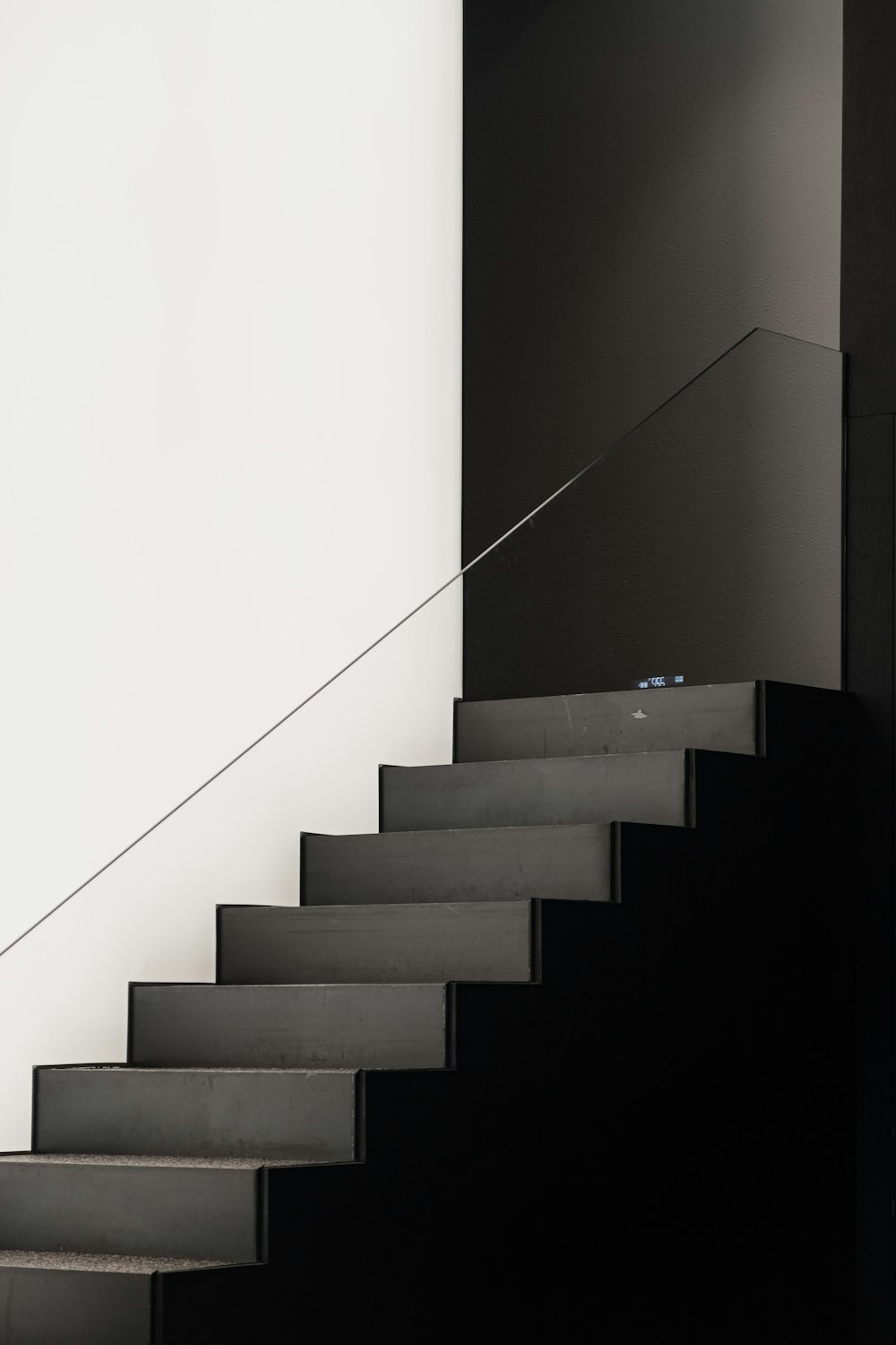 black concrete staircase with white wall