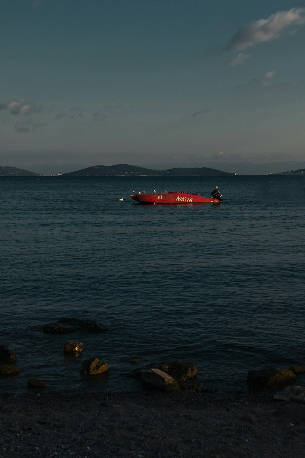 red boat on body of water during daytime