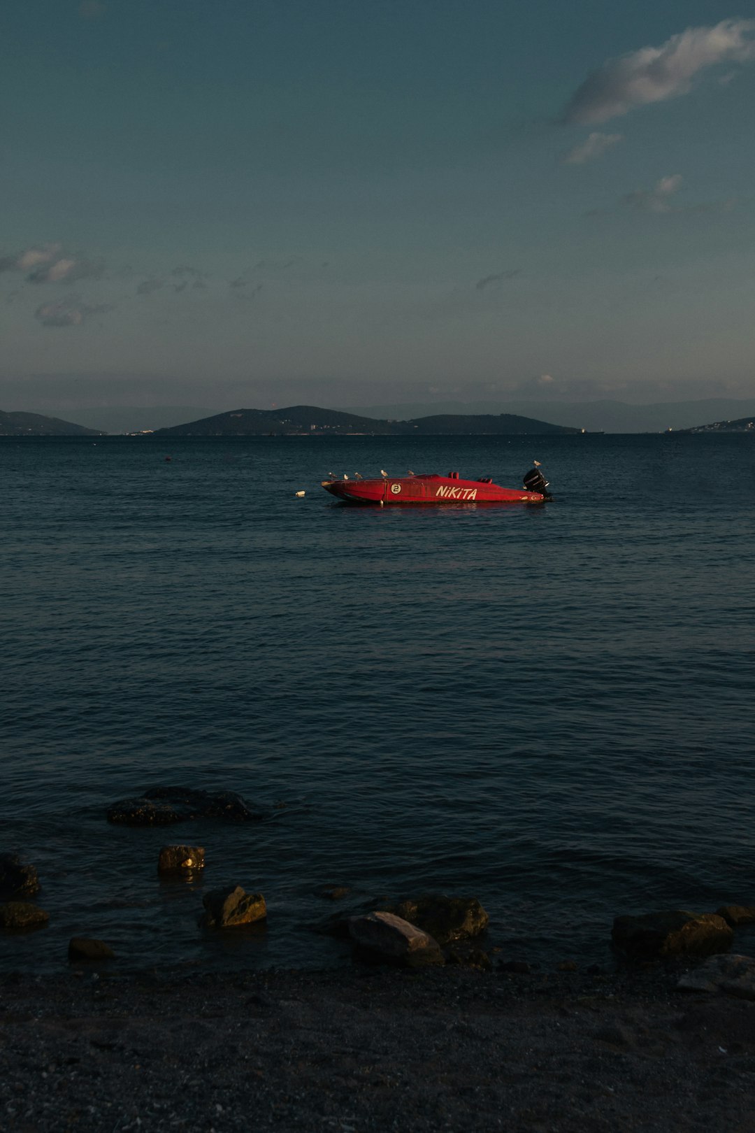 red boat on body of water during daytime