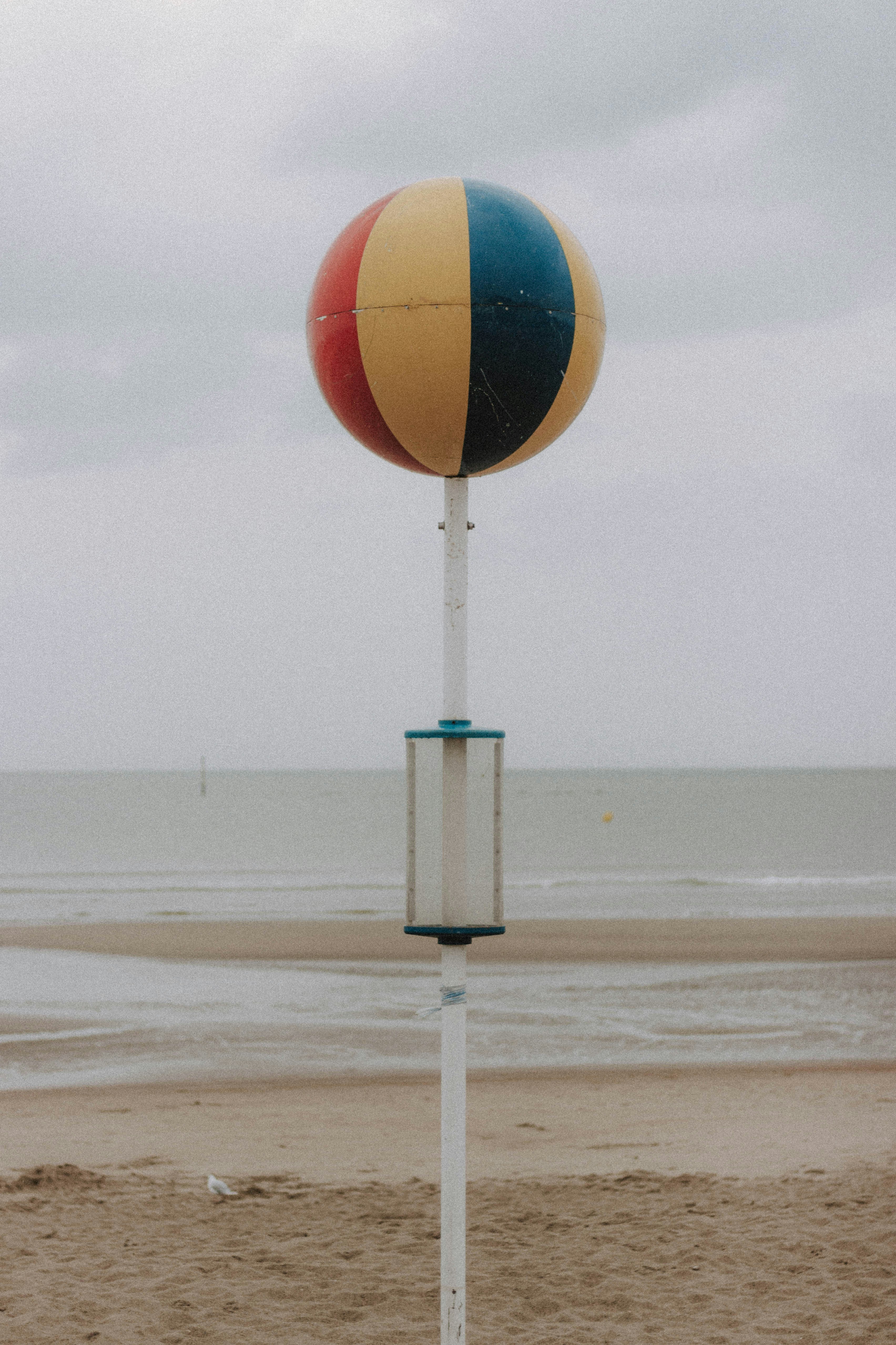 a beach ball sitting on top of a white pole
