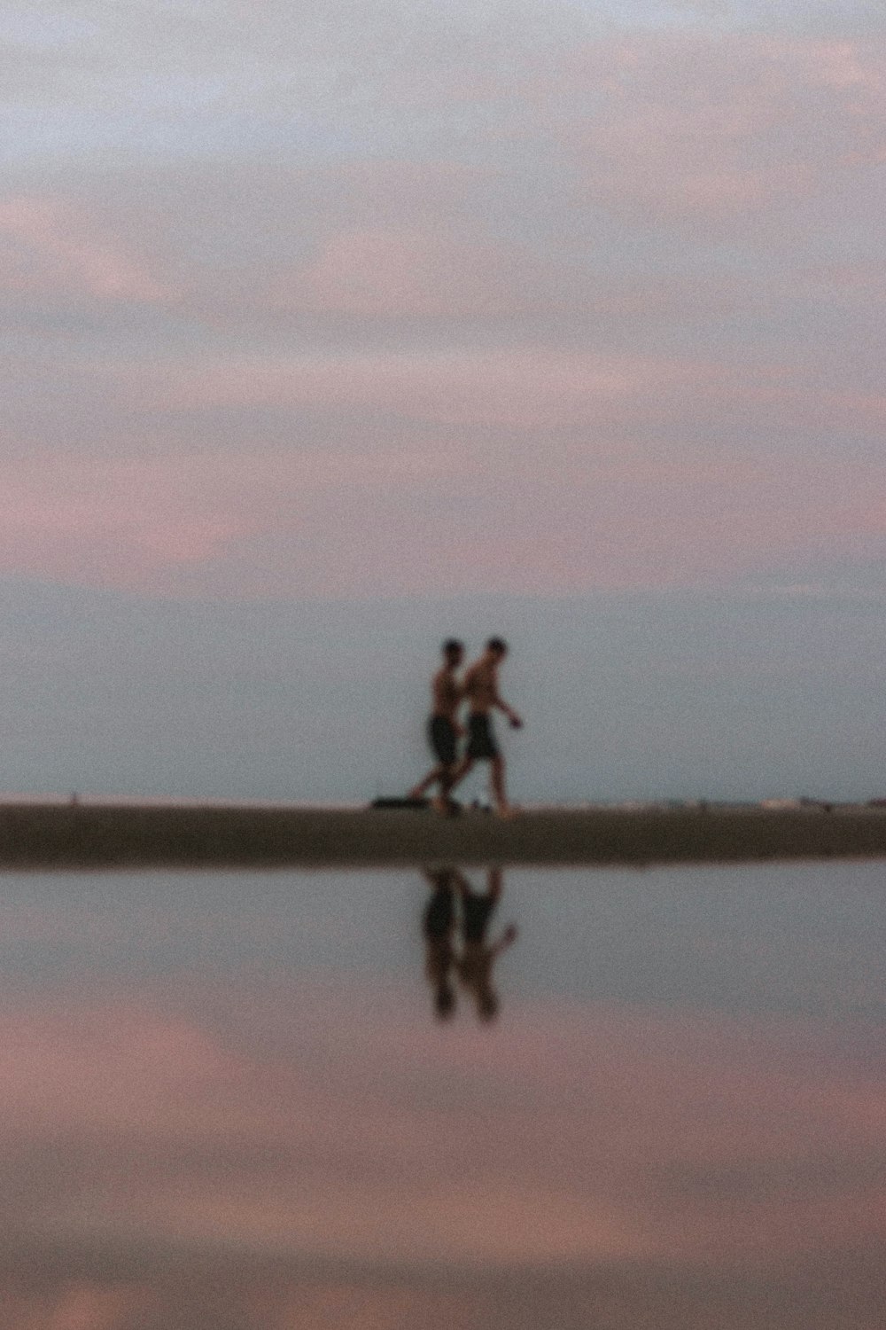 2 person walking on brown sand during daytime