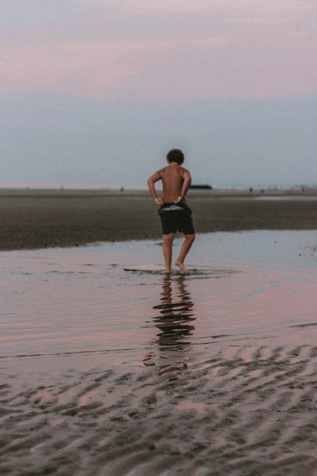 man in black shorts walking on sand during daytime