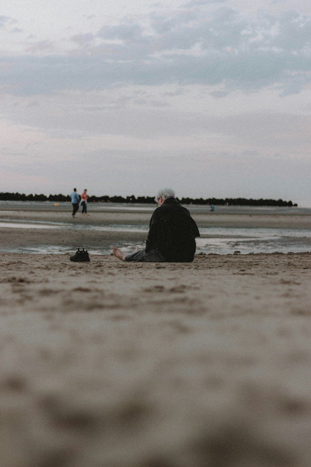 people sitting on seashore during daytime