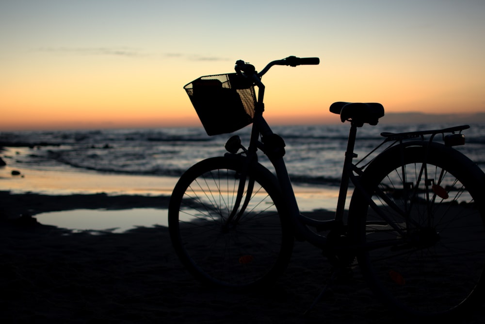 black bicycle on beach during sunset