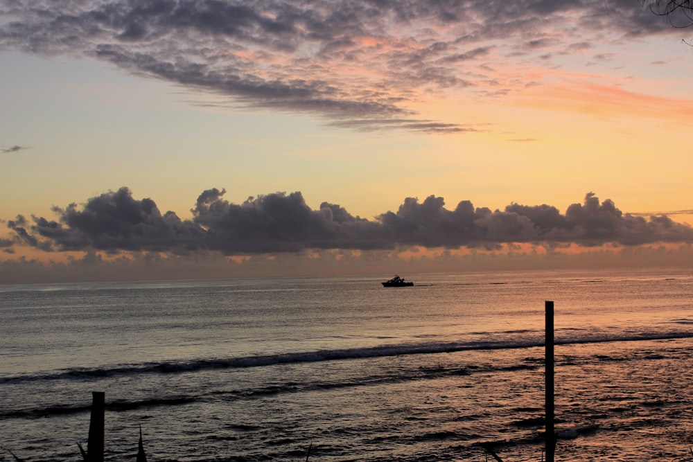 silhouette of boat on sea during sunset