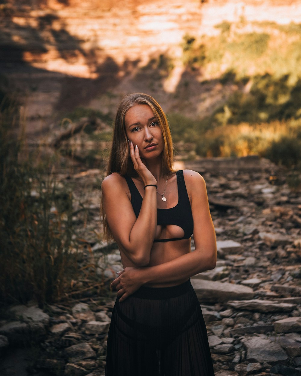 woman in black tank top and black skirt standing on brown soil