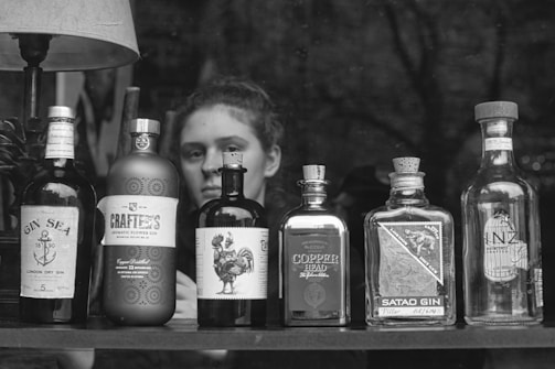 A vibrant display of colorful gin bottles with botanical illustrations on their labels.