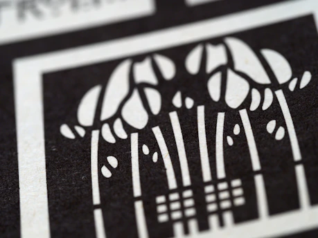 A striking black and white abstract design with intricate letter and special character patterns.