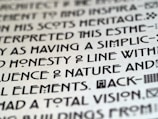 Close-up image of text with a unique, artistic typeface on a light background, featuring bold, geometric characters.