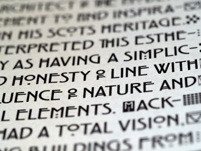 Close-up image of text with a unique, artistic typeface on a light background, featuring bold, geometric characters.