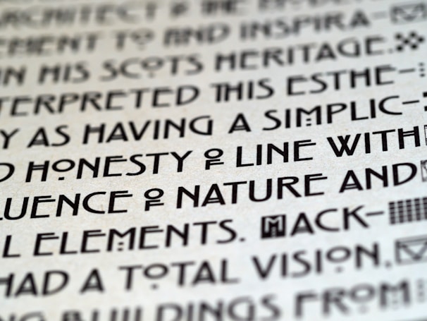 Close-up image of text with a unique, artistic typeface on a light background, featuring bold, geometric characters.