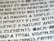 Close-up image of text with a unique, artistic typeface on a light background, featuring bold, geometric characters.