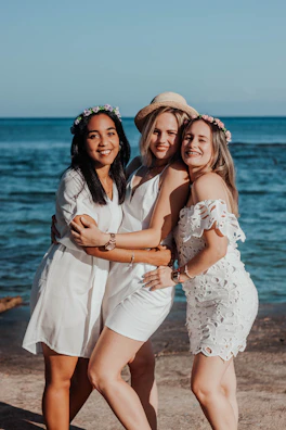 A group of women sharing a heartfelt moment during a coaching retreat by the ocean.