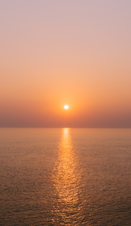 A serene sunset over a calm sea with golden and deep blue hues reflecting the theme of biblical prophecy.