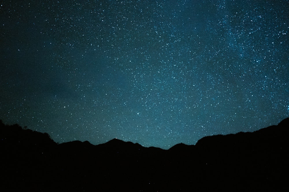 silhouette of mountain under blue sky during night time