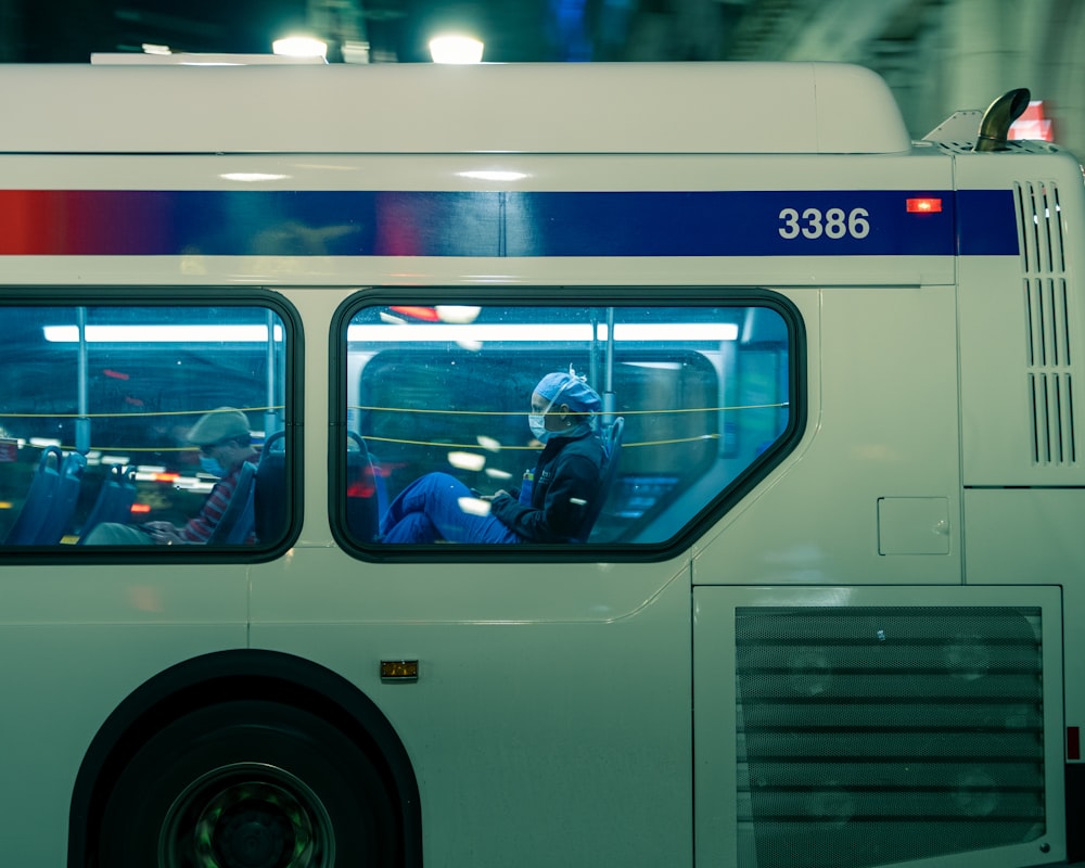 man in black jacket sitting on white bus