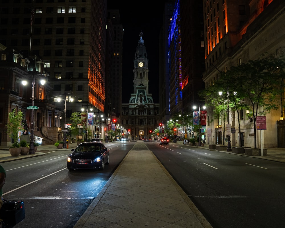 cars on road near high rise buildings during night time