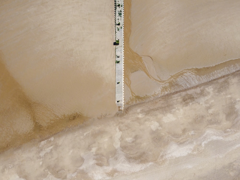 white wooden dock on white sand