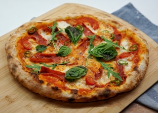 pizza with green leaves and red sauce