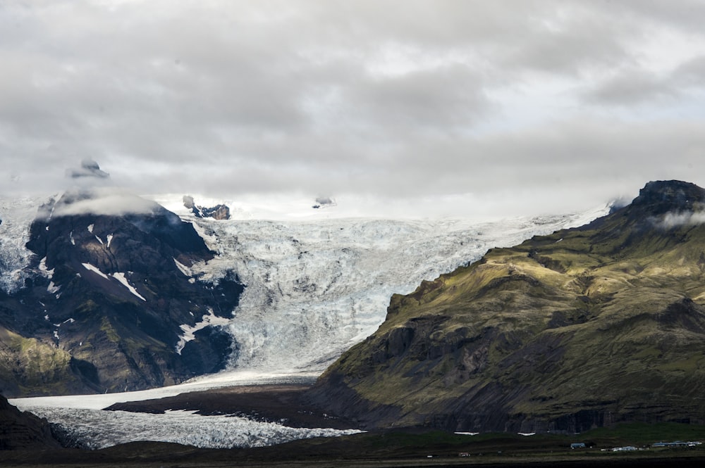 montagne blanche et noire sous des nuages blancs pendant la journée