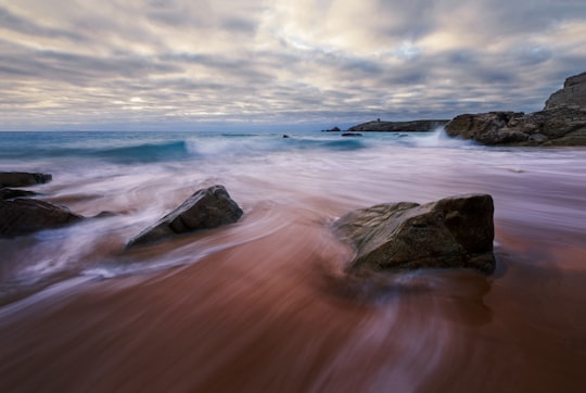 ocean waves crashing on rocks under cloudy sky during daytime in Quiberon France