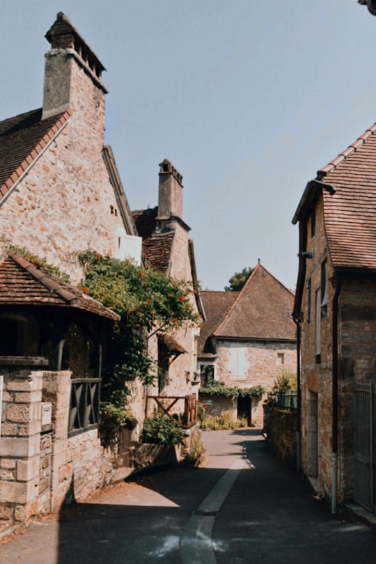 brown brick building near river during daytime in Carennac France