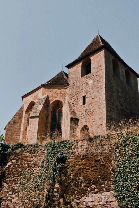 brown brick building on green grass field in Château de Castelnau France