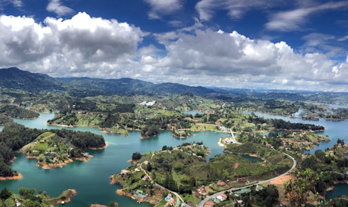 aerial view of city near lake under cloudy sky during daytime