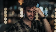 man in black and white plaid button up shirt smiling