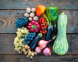 a variety of fruits and vegetables on a wooden surface