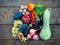 a variety of fruits and vegetables on a wooden surface
