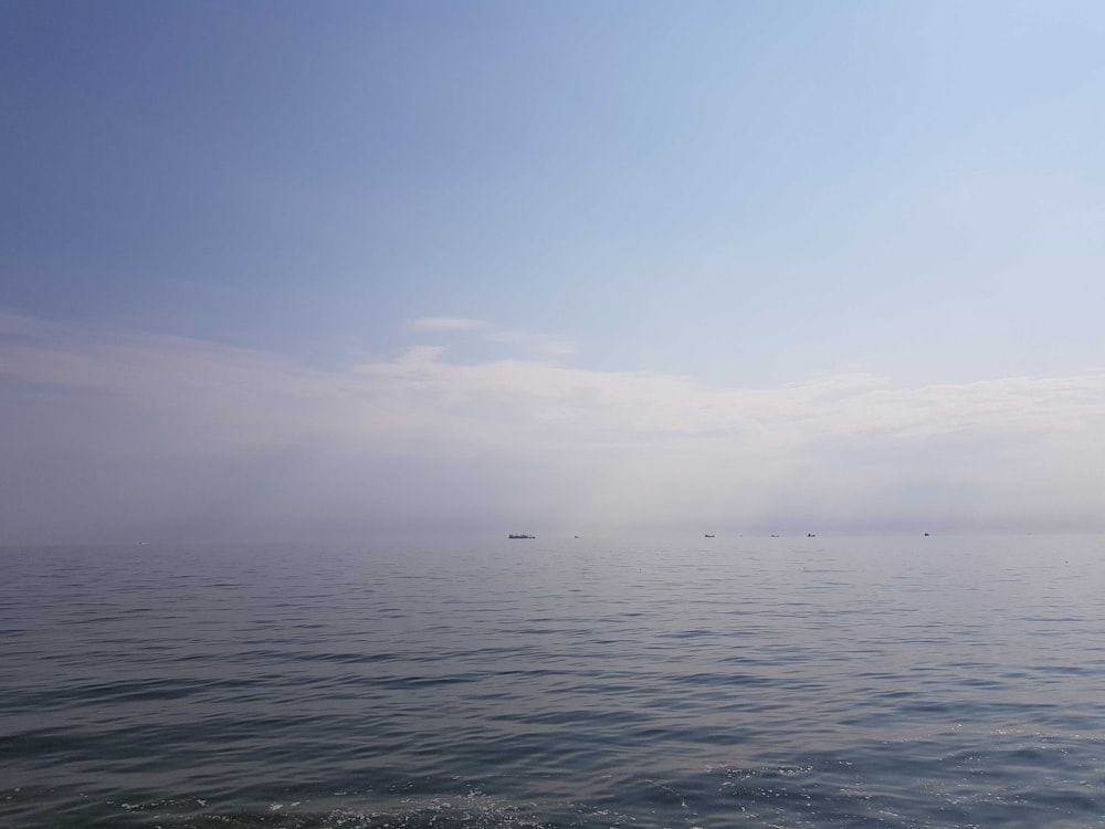 body of water under white sky during daytime