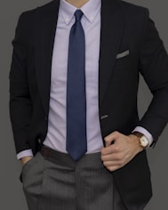 man in black suit jacket and blue necktie