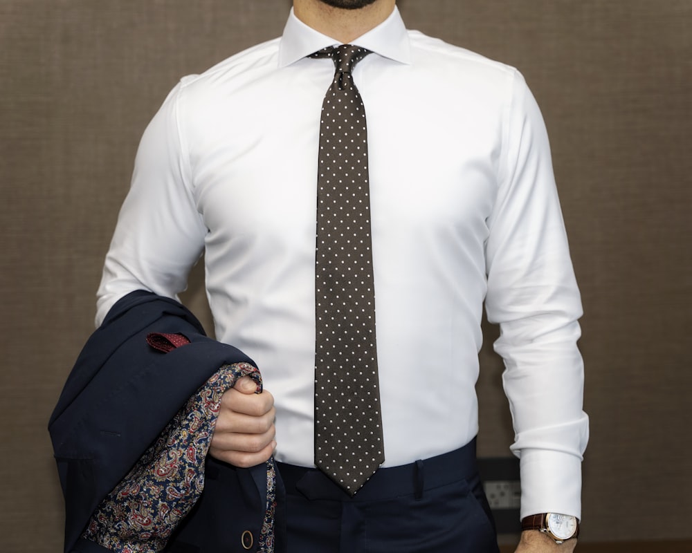 man in white dress shirt with black and white polka dots necktie