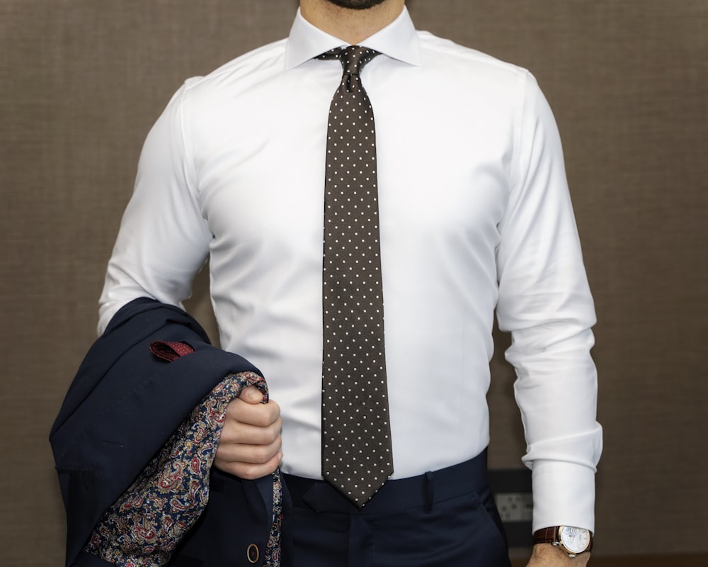 hombre en camisa de vestir blanca con corbata de lunares blancos y negros