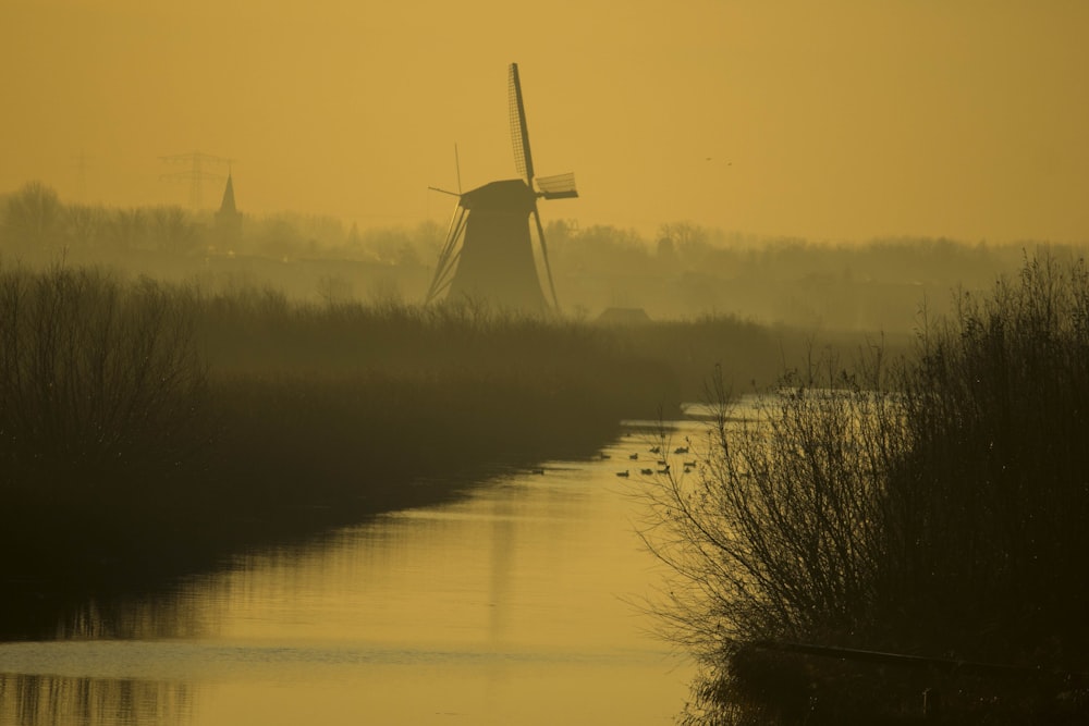 moulin à vent près d’un plan d’eau pendant la journée