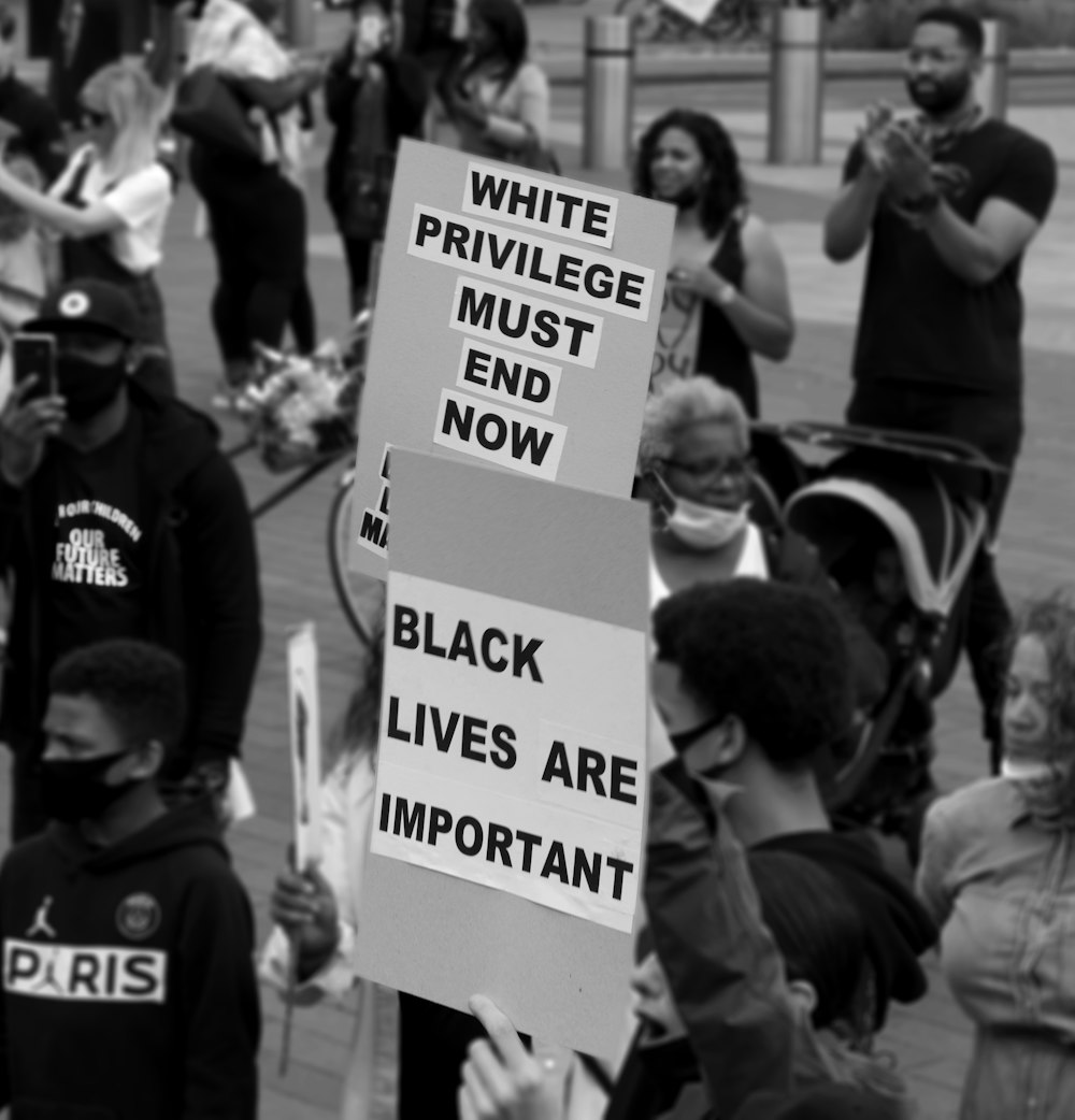 a group of people standing around each other holding signs