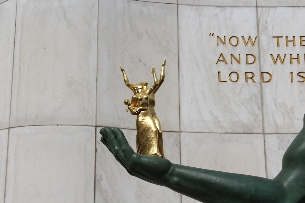 gold human figure on gray concrete wall