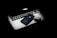 A sleek Apple laptop with its logo glowing subtly is partially covered by an iPhone and a pair of wireless earbuds. The objects are arranged on a dark surface, creating a modern and minimalistic composition with a focus on technology.