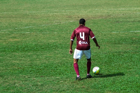 man in blue and white nike jersey shirt and white shorts playing soccer on green grass