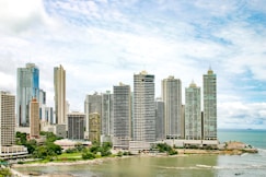 city buildings near body of water under blue sky during daytime