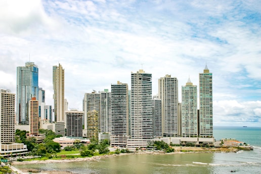 city buildings near body of water under blue sky during daytime