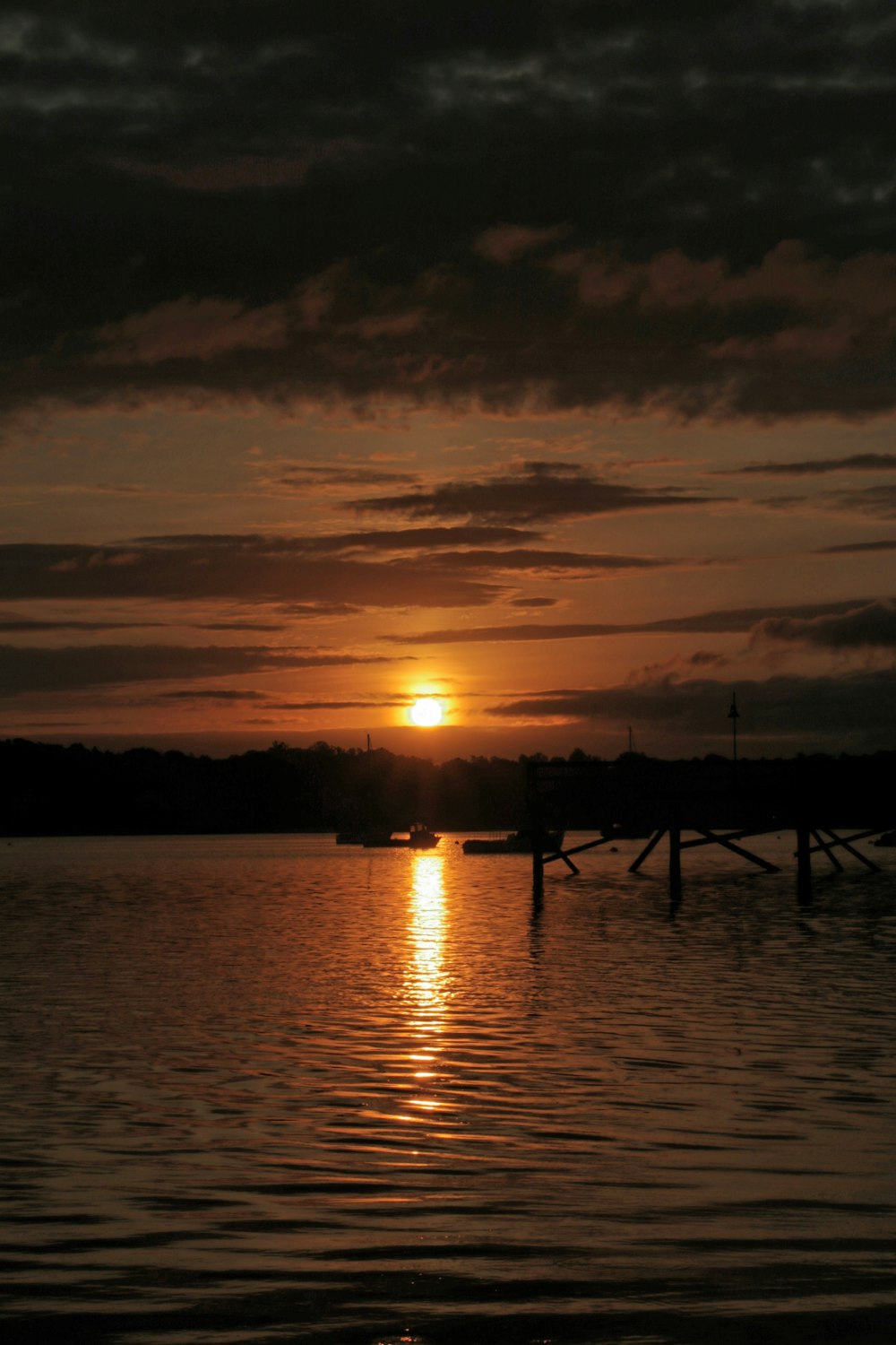 silhouette of people on dock during sunset