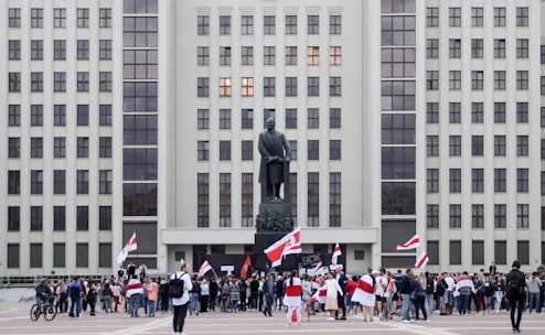 A group of citizens attentively observing a government building during a public meeting.