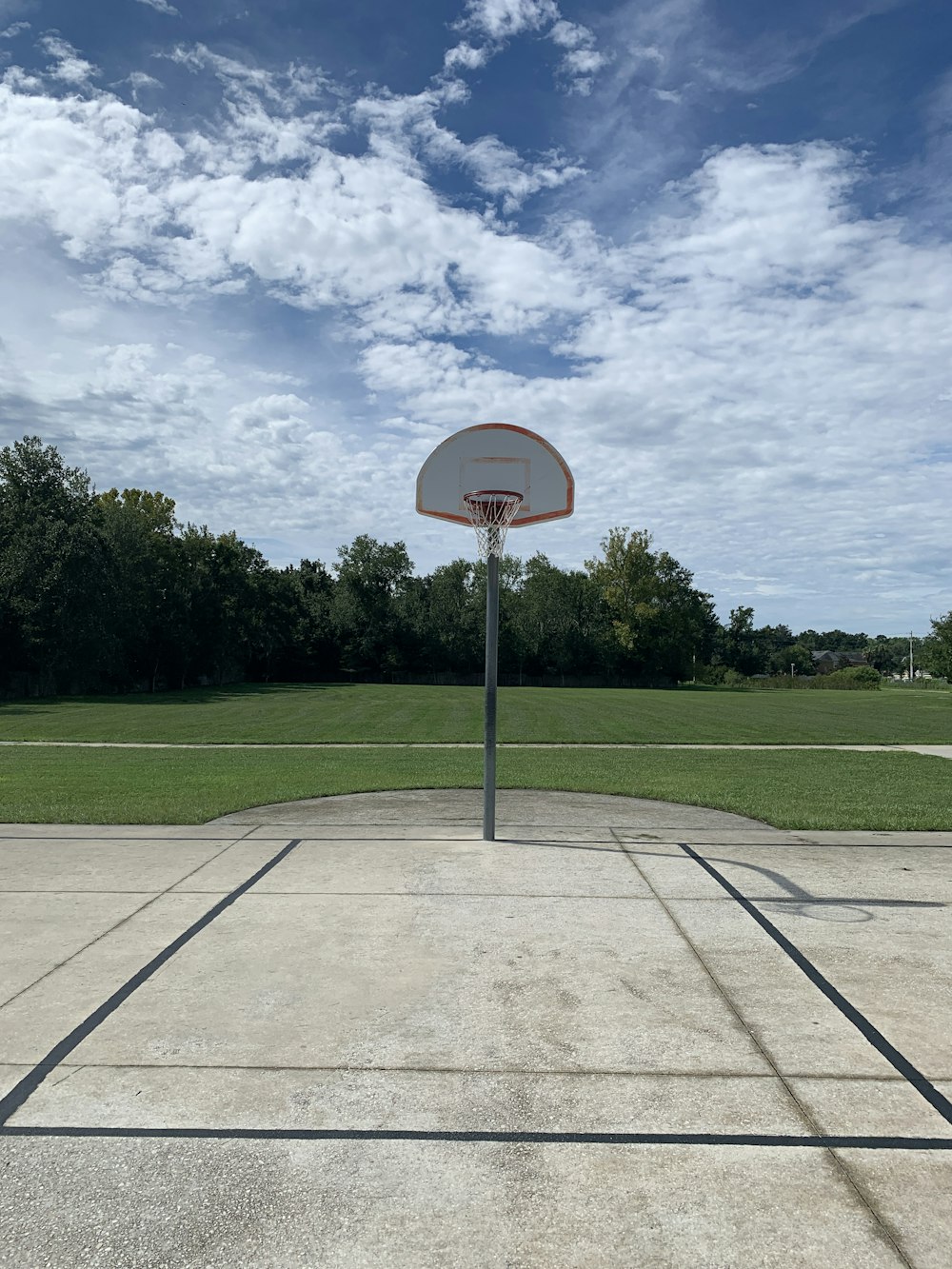 basketball hoop on green grass field under blue sky during daytime