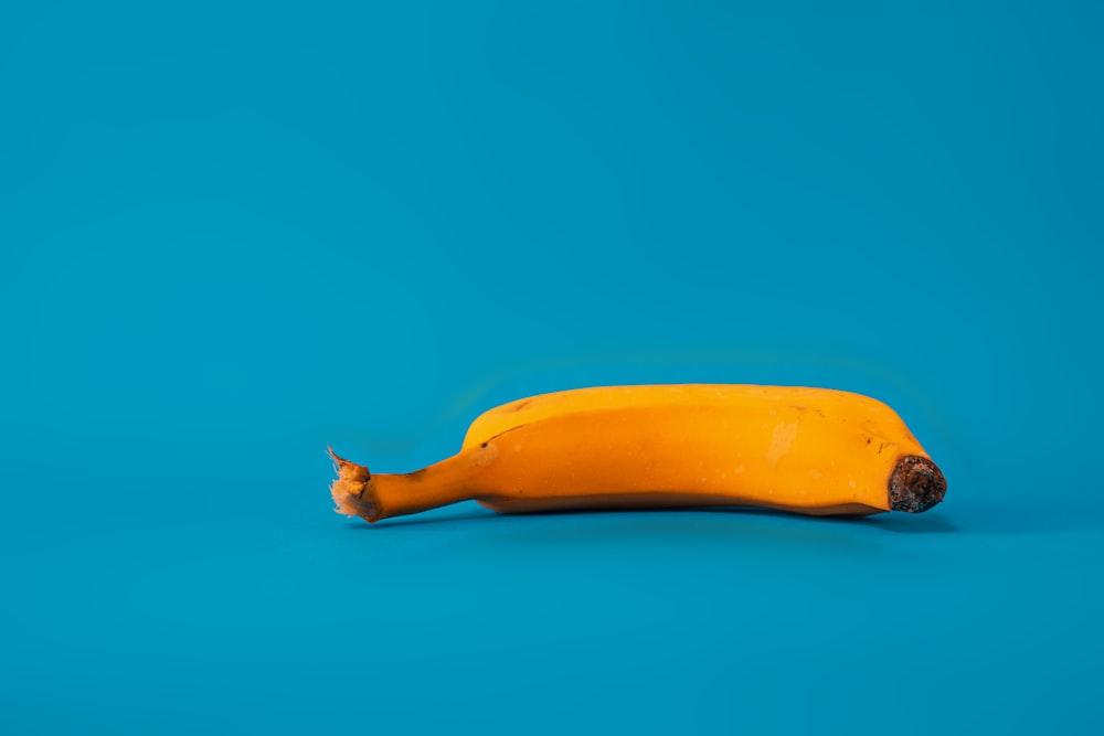 fruit de banane jaune sur surface bleue