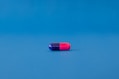 red and blue pill on blue surface