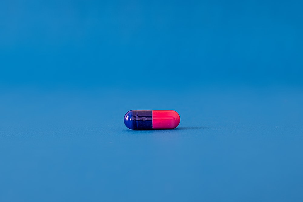 red and blue pill on blue surface